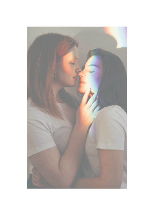 To kvinder dækket af regnbuefarvet lys der kærtegner hinanden