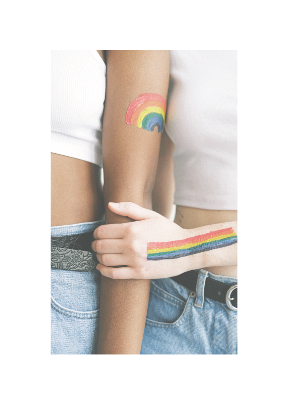 To kvinder med regnbueflag på armene der kærtegner hinanden