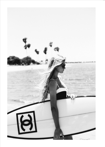 fotoplakat af kvinde på stranden med sit chanel surfboard i sort hvid